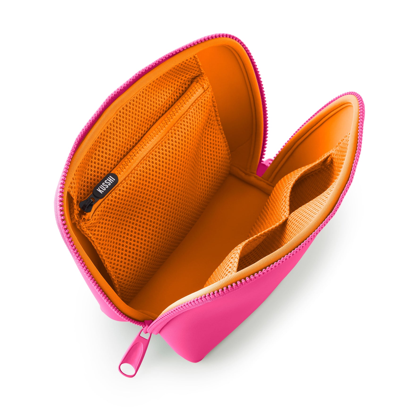 Digital photograph by KUSSHI of an open bright pink cosmetic bag on a white background, featuring a vibrant orange interior with multiple mesh pockets and a black zipper pull embossed with the KUSSHI logo