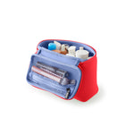 A vibrant red KUSSHI cosmetic bag with a sky blue interior and mesh pocket, filled with an assortment of travel-sized beauty products, featuring the KUSSHI logo on its zipper pull, displayed on a clean white background