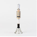Nutcracker shaped taper candle in gold and silver uniform on a glass stand