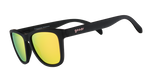 A pair of Goodr Professional Respawner sunglasses with matte black frames, vibrant yellow-green mirrored lenses, and a pink goodr logo on the temple, resting on a clear acrylic stand