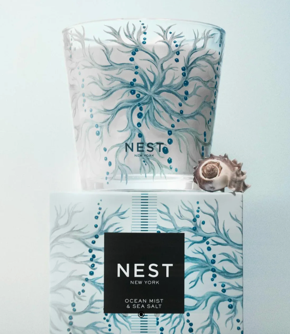 Nest New York Ocean Mist & Sea Salt scented candle and box featuring a serene blue-green coral and bubble design, accented by a small natural spiral seashell