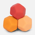 Three stacked hexagonal silicone sensory blocks in red orange and light orange