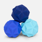 Three geometric textured balls in shades of blue stacked on a white background