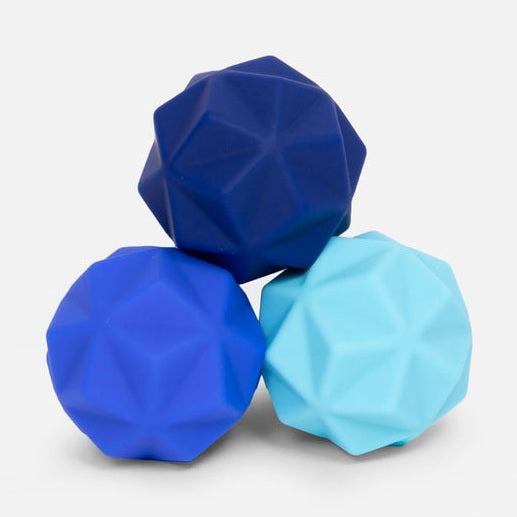 Three geometric textured balls in shades of blue stacked on a white background