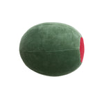A large plush olive green decorative cushion shaped like a stuffed olive featuring a bright red pimento detail and visible horizontal stitching