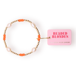 Handcrafted jewelry by Beaded Blondes featuring a 14k gold-filled bracelet with four luminous white freshwater pearls and vibrant orange seed beads next to a pink logo tag on a white background