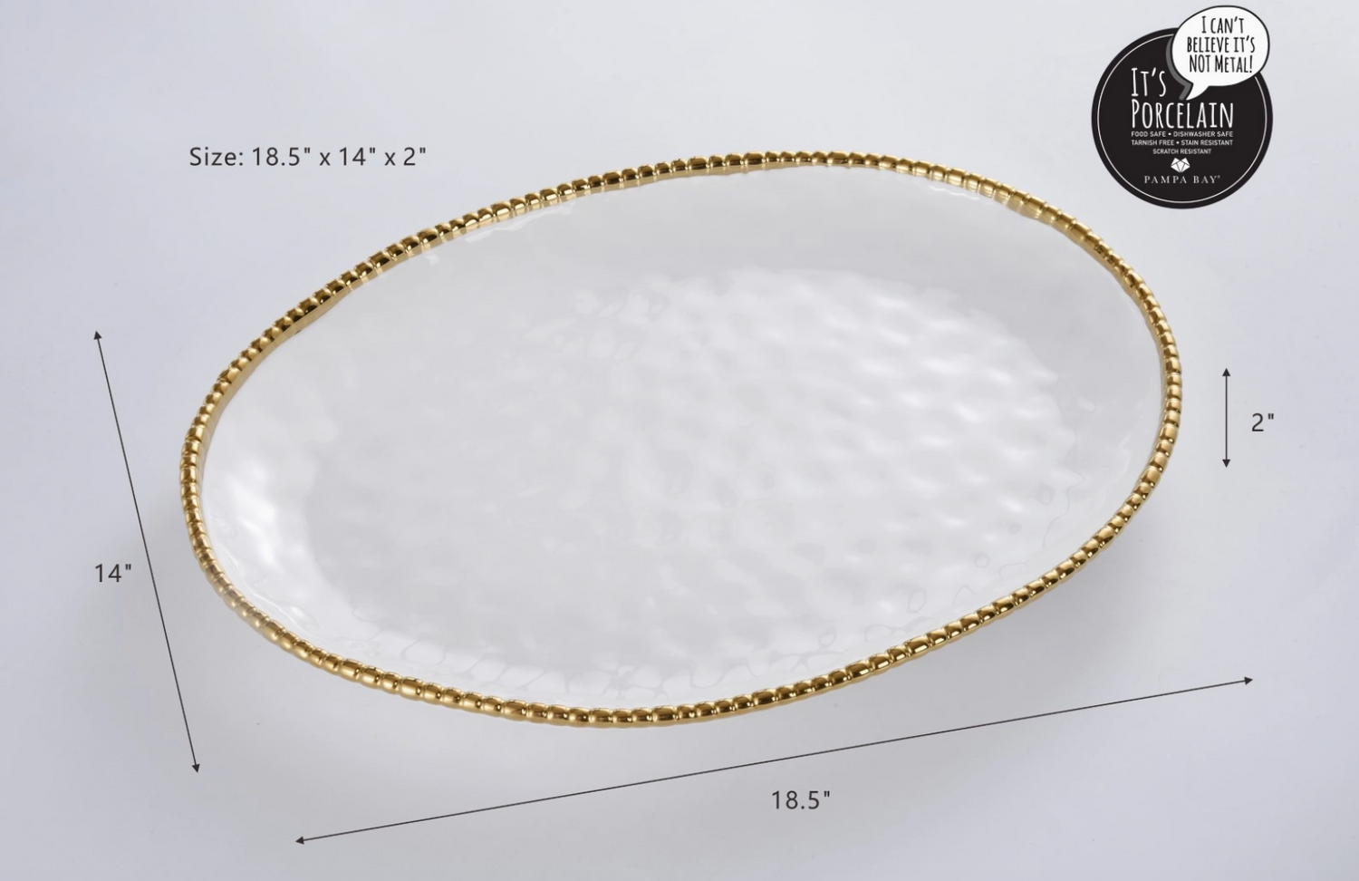 Pampa Bay porcelain oval serving platter with hammered texture, gold beaded rim, and dimensions 18.5 by 14 by 2 inches, prominently displaying its "It's Porcelain, I can't believe it's not metal!" branding in a studio setting