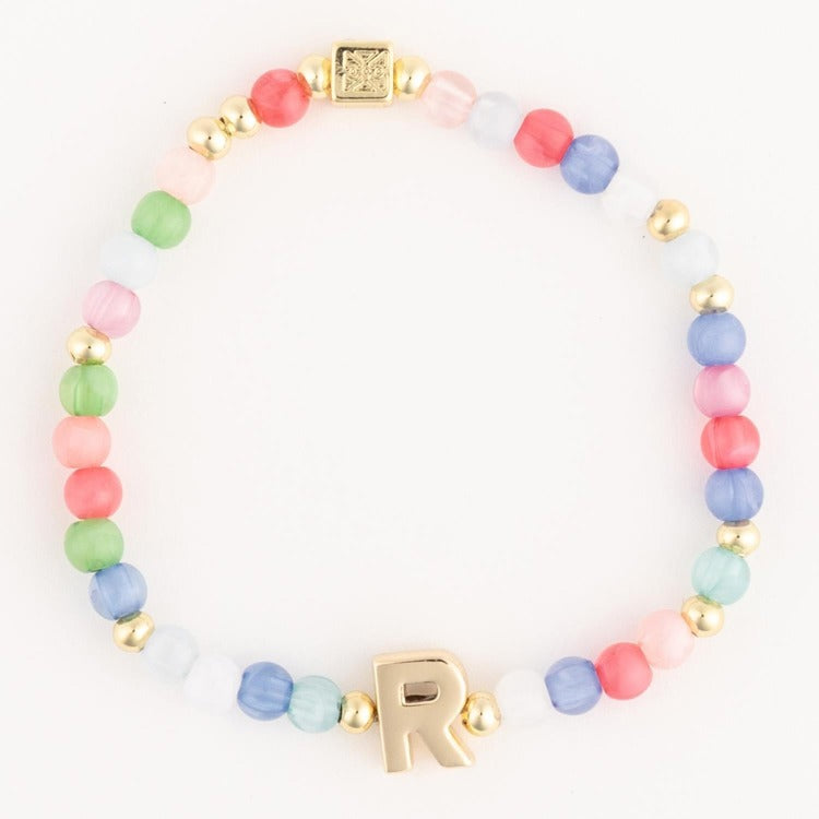 Pastel matte glass beaded bracelet featuring pink green blue and white beads interspersed with gold accents including a prominent gold letter R charm and a small etched square bead