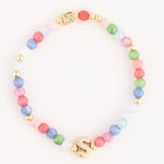 Jewelry a multicolor pastel beaded bracelet featuring gold accent beads a prominent gold initial S charm and a small embossed square gold bead