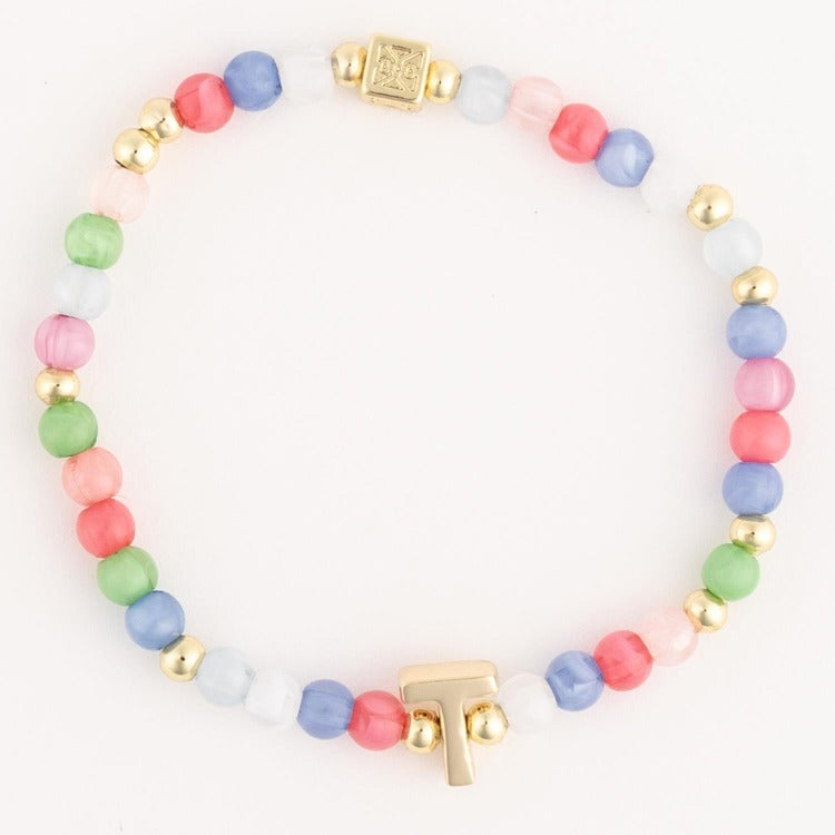 Multicolor pastel glass beaded bracelet with alternating gold spacer beads, a gold T-shaped charm, and a decorative gold rectangular clasp