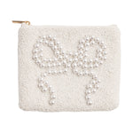 White beaded clutch bag featuring a prominent bow design crafted from larger white pearls with a subtle gold zipper pull