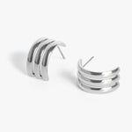 Pair of silver-toned triple-banded C-shaped hoop earrings with a polished finish on a white background