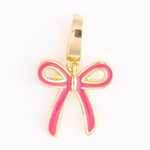 A shiny gold-toned bow charm with vibrant pink enamel detailing and a top loop for attachment