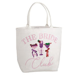White canvas tote bag featuring pink sequin text 'THE BRIDE Club' with three colorful sequined cocktail illustrations including a purple strawberry drink, a margarita, and a green martini with olives