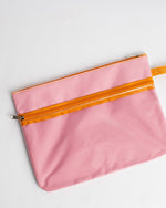 Pink fabric zipper pouch with orange zipper trim