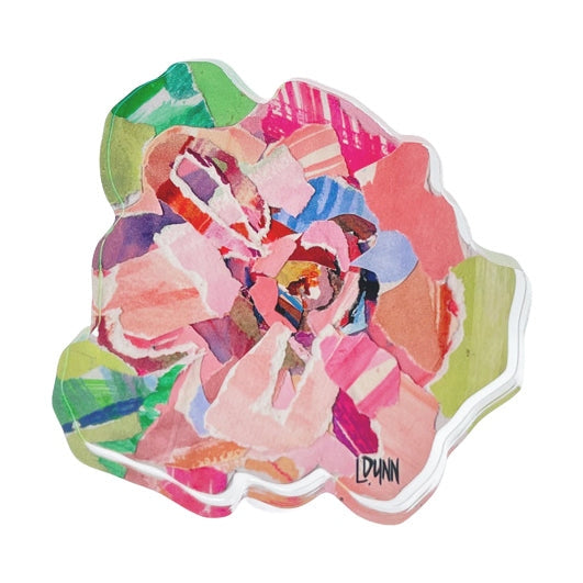 Mixed media collage by LDUNN depicting an abstract flower bloom composed of torn paper fragments in vibrant pinks, greens, blues, and purples, with a distinctive irregular organic shape and clear resin edge