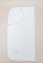 White baby blanket with light blue scalloped trim and an embroidered cross symbol