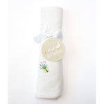 Goosies fabric rolled white baby blanket with a white ribbon, an embroidered pink tulip bouquet, and a "Goosies" tag depicting three geese