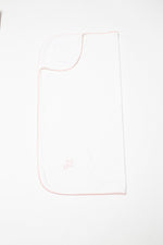 White baby blanket featuring pink scalloped trim and a small embroidered pink cross