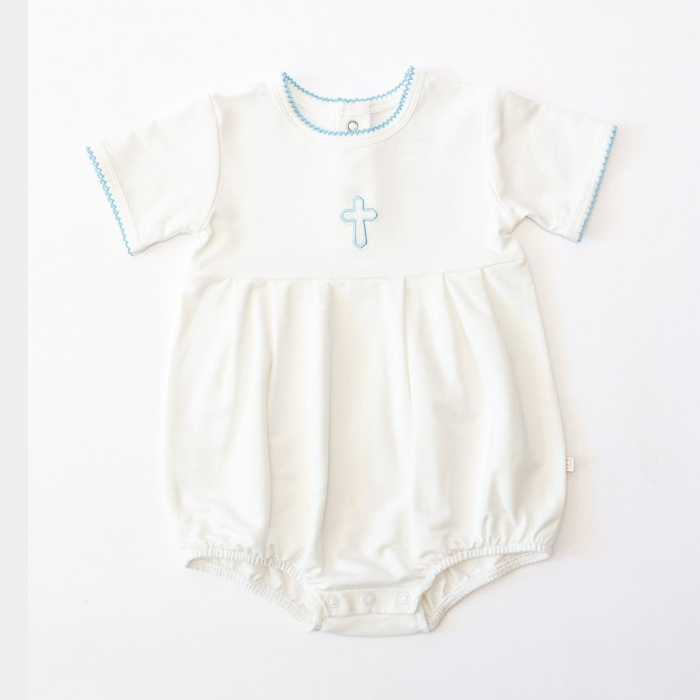 White baby romper featuring a light blue embroidered cross, delicate blue scalloped trim on the round neckline and short sleeve cuffs, and snap closures at the bottom