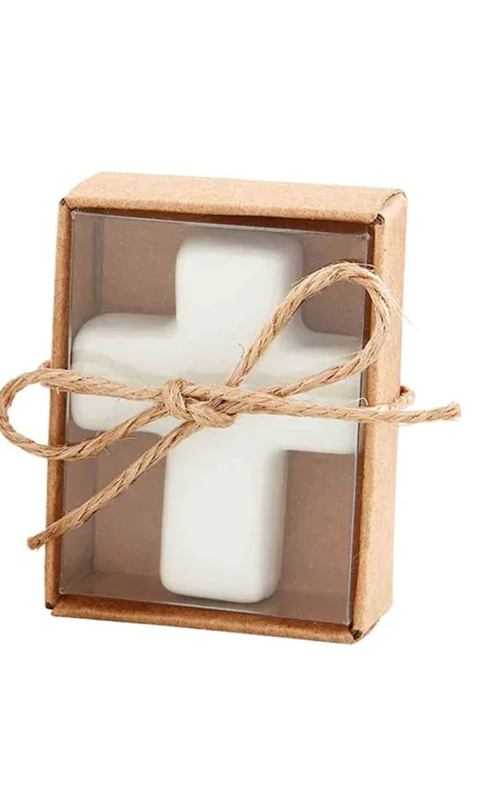 A white ceramic cross displayed inside a kraft paper gift box featuring a clear plastic window and tied with a rustic jute twine bow