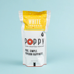 Product photo of a white and yellow stand-up pouch of Poppy Hand-Crafted White Cheddar Popcorn featuring a red poppy flower in the logo and a gluten-free badge on a light blue background