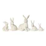 Five white ceramic bunny figurines of varying sizes are displayed on a white background featuring glossy finishes and upright ears