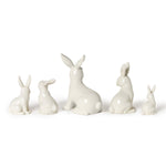 Ceramic collection of five glossy white rabbit figurines of various sizes arranged against a plain white background