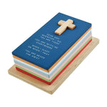 Stacked wooden blocks with a cross on top and printed religious text