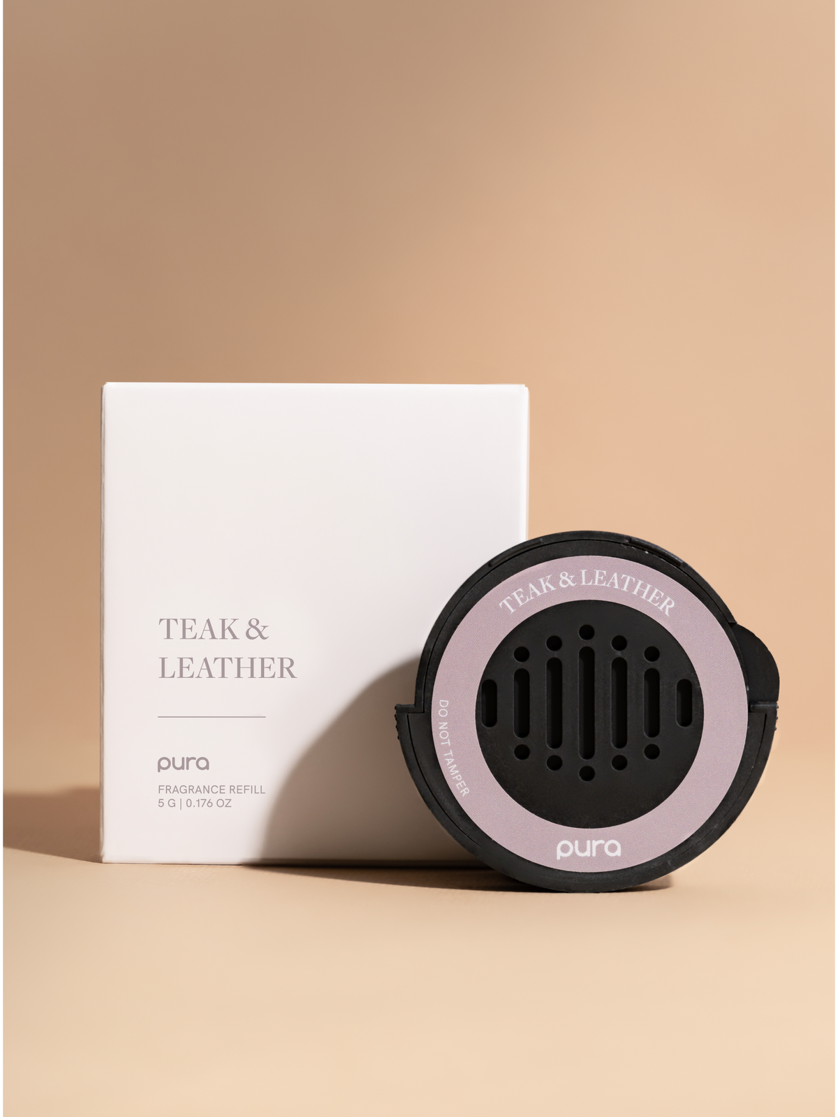 Black car fragrance diffuser with a pink ring beside its box