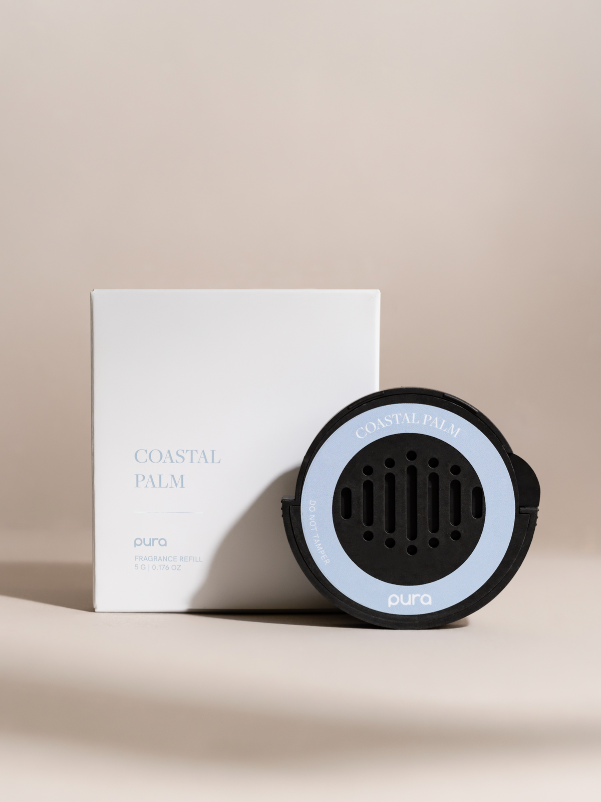 Black car fragrance diffuser with a blue ring beside its box