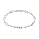 A silver beaded bracelet featuring a delicate arrangement of varying sized polished metallic beads
