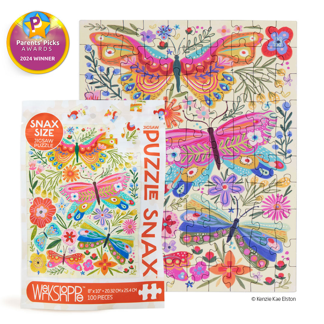 Illustrated jigsaw puzzle by Kenzie Kae Elston featuring vibrant patterned butterflies and floral motifs on a cream background, shown with its Puzzle Snax packaging and a gold 2024 Parents' Picks Awards winner seal