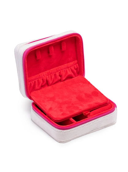 A white and fuchsia pink zippered jewelry box open to reveal a vibrant red velvet interior with earring holders and a removable divider on a white background
