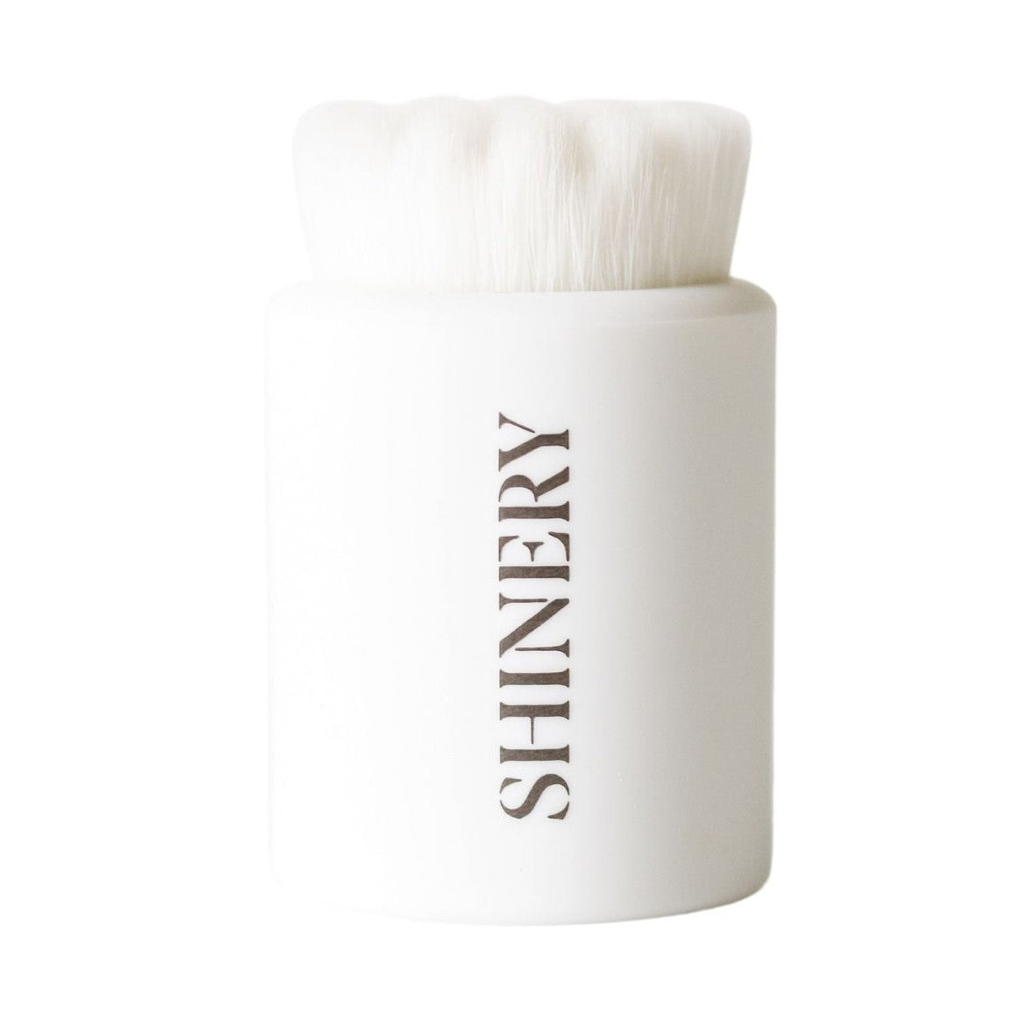 Product photo of a white SHINERY facial cleansing brush featuring soft white bristles and brown vertical branding on its handle against a plain white background