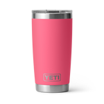 Digital photograph of a YETI Rambler tumbler featuring a vibrant coral pink body, stainless steel base and upper rim, an embossed YETI logo, and a clear MagSlider lid, isolated on a white background with a soft cast shadow