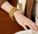 Gold twisted rope bangle worn on a wrist