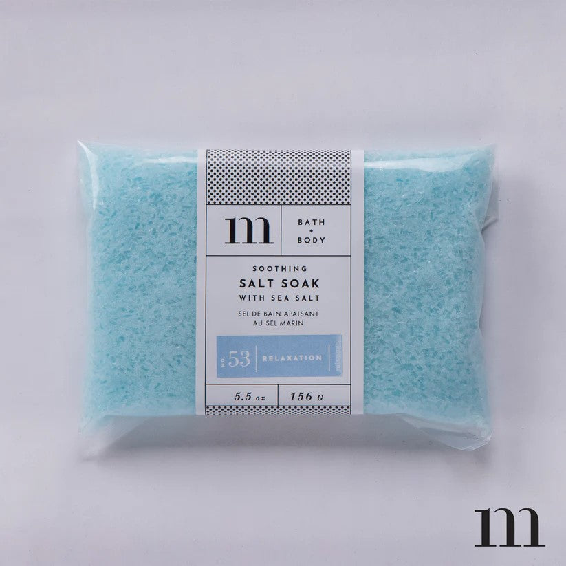 Clear plastic pouch filled with blue bath salt crystals and a white product label