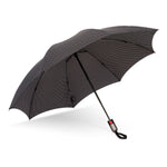Automatic folding umbrella black with white polka dots a striped edge and a red button on the grey handle