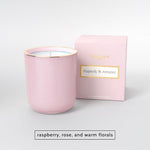 Pink scented candle in a glass jar with matching box labeled Rhapsody and Romance