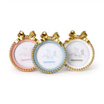 Three decorative round photo frames, one pink, one baby blue, and one white, each with a gold beaded rim and a large gold bow, featuring a line drawing of a fox and butterfly, presented on a white background