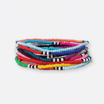 Handcrafted seed bead bracelets stacked in a vibrant array of colors, including solid red, yellow, blue, and pink, with some bands featuring black and white stripes
