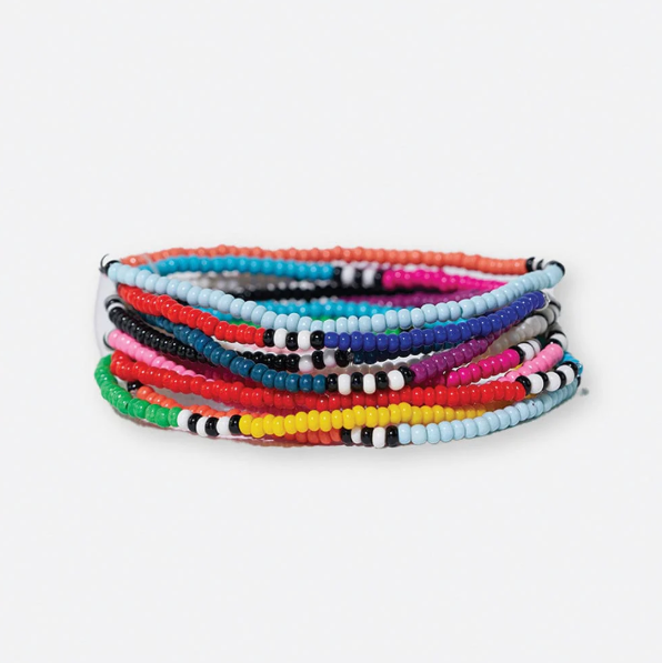 Handcrafted seed bead bracelets stacked in a vibrant array of colors, including solid red, yellow, blue, and pink, with some bands featuring black and white stripes