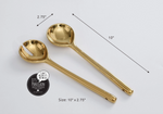 Pampa Bay porcelain gold-tone salad servers, one slotted and one solid spoon, displayed on a white surface with dimensions of 10 inches long and 2.75 inches wide and notable for being porcelain rather than metal