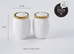 Pampa Bay porcelain salt and pepper shakers featuring elegant white oval bodies and ornate gold textured rims, displayed on a clean white background with dimensions 2.5 inches D by 3.25 inches H