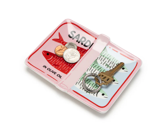 Ceramic sardine can-shaped trinket dish in pink and light blue with fish illustrations, containing US coins and a brass key