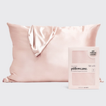 Product photo of a smooth blush pink satin pillowcase with elegant folds next to its Kitsch retail box featuring THE SATIN pillowcase 600 THREAD COUNT for hair and skin benefits