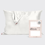 Kitsch white satin pillowcase draped showing a small red tag next to its pink packaging highlighting 600 thread count and the text Seriously So Soft