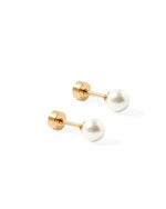 Pair of minimalist white round pearl stud earrings with shiny gold-toned screw-back posts on a clean white background