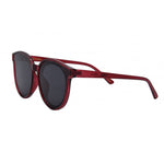 I-SEA Sedona sunglasses featuring transparent deep red frames, dark grey lenses with a subtle cat-eye round shape, and the Sedona model name visible on the frame